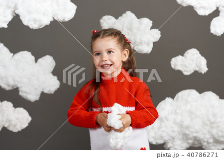 girl playing with clouds, dressed in red sweater girl playing with clouds, dressed in red sweater 40786271