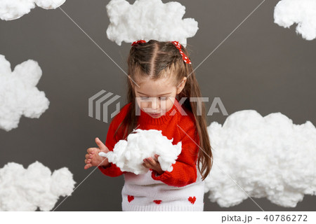 girl playing with clouds, dressed in red sweater girl playing with clouds, dressed in red sweater 40786272