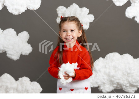 girl playing with clouds, dressed in red sweater 40786273