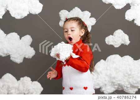 girl playing with clouds, dressed in red sweater 40786274