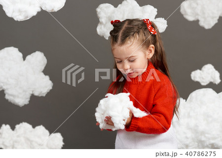 girl playing with clouds, dressed in red sweater girl playing with clouds, dressed in red sweater 40786275