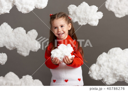 girl playing with clouds, dressed in red sweater girl playing with clouds, dressed in red sweater 40786276