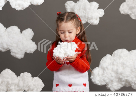 girl playing with clouds, dressed in red sweater 40786277