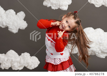 girl playing with clouds, dressed in red sweater girl playing with clouds, dressed in red sweater 40786278
