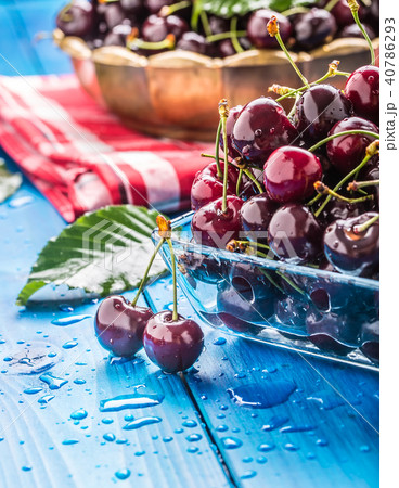Ripe sweet cherries on blue woden table with water 40786293
