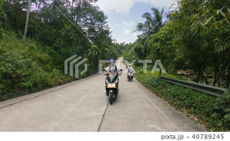 Man drive bike scooter on the road with palms in Thailand Man drive bike scooter on the road with palms in Thailand 40789245