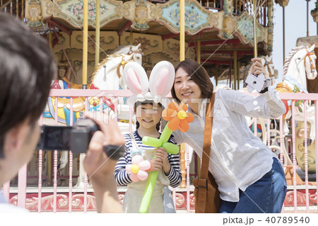 遊園地でお母さんと娘を撮影するお父さん 遊園地でお母さんと娘を撮影するお父さん 40789540