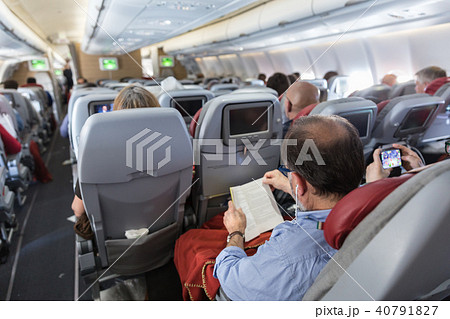 Interior of large commercial airplane with passengers on their seats during flight. 40791827