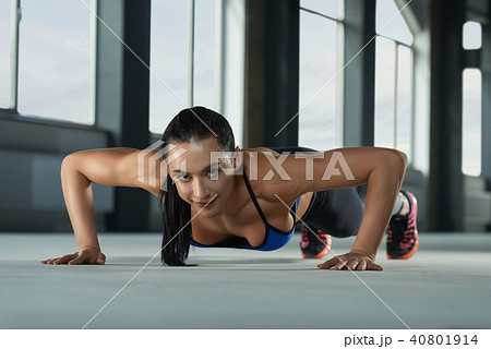 Young sporty girl with athletic body doing push ups on the gym floor. Young sporty girl with athletic body doing push ups on the gym floor. 40801914