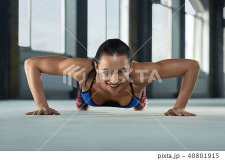 frontview of young sporty girl with athletic body doing push ups on gym floor. 40801915