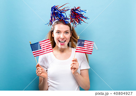 Happy young woman holding an American flag Happy young woman holding an American flag 40804927