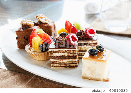 Set of mini cakes in assortment on white plate. 40810086