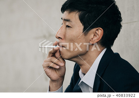 煙草を吸う若いビジネスマンの写真素材
