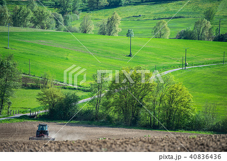 Tractor plowing field and beautiful landscape, France 40836436
