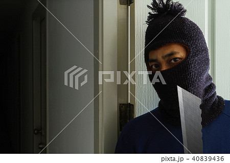 Masked robber with knife hiding behind the door Masked robber with knife hiding behind the door 40839436