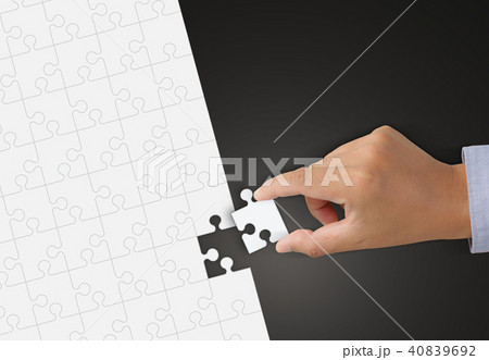 Hand holding Piece of white Jigsaw puzzle  40839692