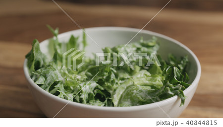 frillis salad leaves falling into white bowl 40844815