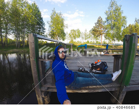 The young man makes a selfie sitting on the pier The young man makes a selfie sitting on the pier 40846685