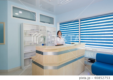 friendly young woman behind the reception desk administrator friendly young woman behind the reception desk administrator 40852753