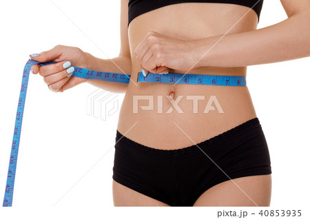 woman measuring waist with blue measuring tape. woman measuring waist with blue measuring tape. 40853935