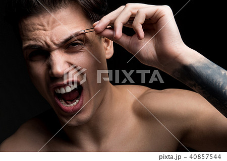 Young guy is plucking his eyebrows 40857544