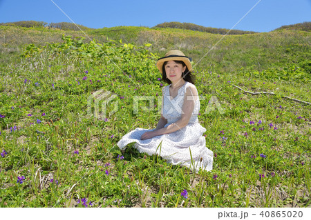 砂浜の海岸で快晴の青空のもと白いワンピースにストローハットの女性のポートレートを撮影 砂浜の海岸で快晴の青空のもと白いワンピースにストローハットの女性のポートレートを撮影 40865020