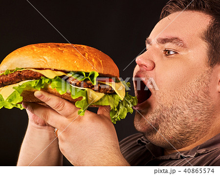 Fat man eating fast food hamberger. Breakfast for overweight person. 40865574