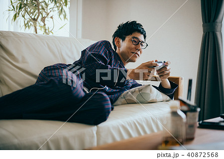 パジャマ姿でゲームに熱中する若い日本人男性 40872568