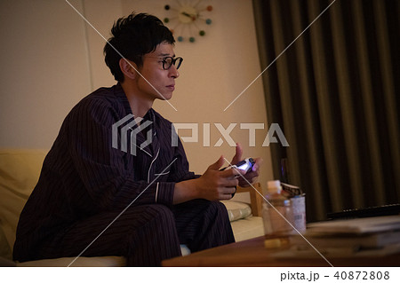 パジャマ姿でゲームに熱中する若い日本人男性 パジャマ姿でゲームに熱中する若い日本人男性 40872808