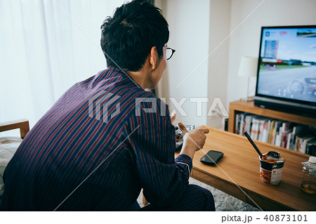テレビゲームに熱中する若い日本人男性の写真素材