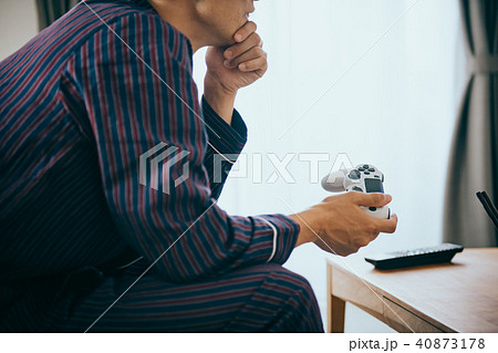 パジャマ姿でゲームをする若い日本人男性 40873178