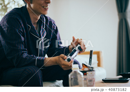 パジャマ姿でゲームをする若い日本人男性 パジャマ姿でゲームをする若い日本人男性 40873182
