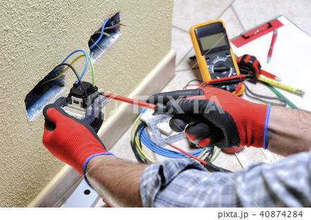 Electrician at work with safety equipment Electrician at work with safety equipment 40874284