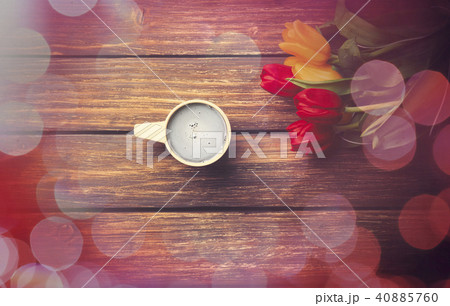 Cup of coffee and tulips on wooden table.  40885760