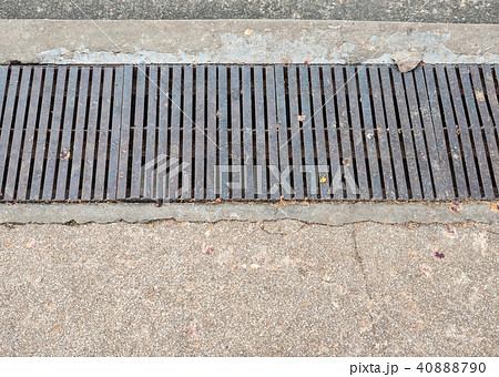 Dirty Steel drain grate beside the pathway. 40888790