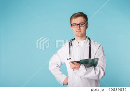 Medical doctor writing prescription over blue background with copy space. 40889832