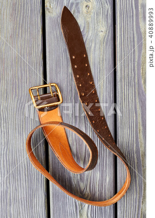 Twisted orange belt on wood. Twisted orange belt on wood. 40889993