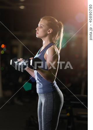 Young woman lifting the dumbbells Young woman lifting the dumbbells 40890780