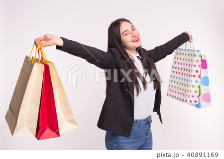 Portrait of young happy brunette woman with shopping bags on white background 40891169