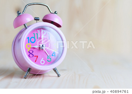 The Pink alarm clock place on the wooden table and The Pink alarm clock place on the wooden table and 40894761