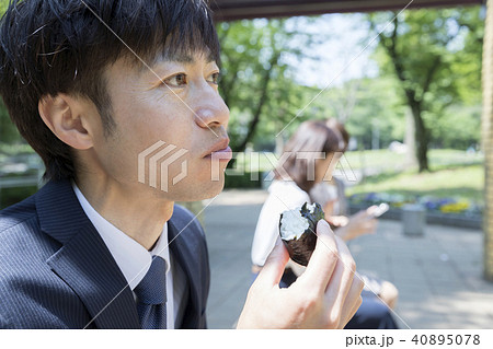 公園のベンチでお昼を食べるビジネスパーソン　営業マン　昼休みイメージ 40895078