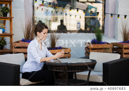 Lovely business woman with smile is sitting with touch pad in comfortable restaurant during 40897683