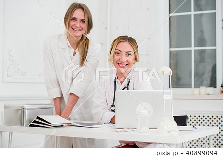 Two Female friendly cheerful Doctors or Nurses Isolated in office smiling and looking at camera 40899094