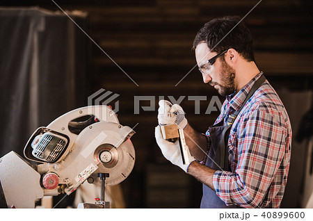 profession, carpentry, woodwork people concept - carpenter with wood plank and notebook checking his profession, carpentry, woodwork people concept - carpenter with wood plank and notebook checking his 40899600