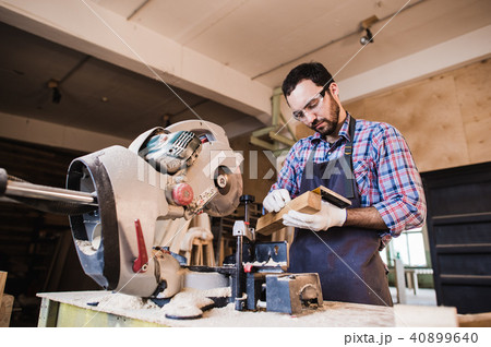 Young craftsman in uniform working at carpentry 40899640