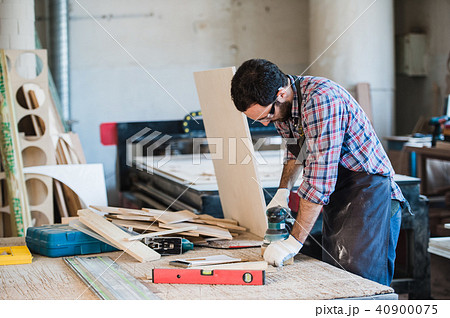 Carpenter with power grinder at his workshop Carpenter with power grinder at his workshop 40900075