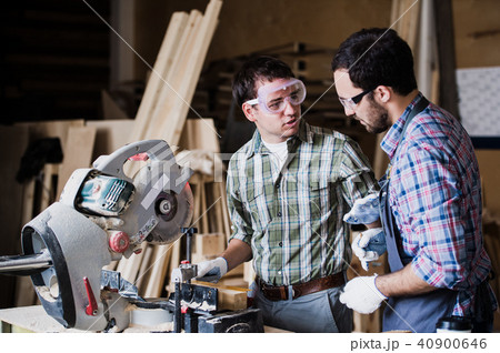 Two men builder with circular saw having a conversation 40900646