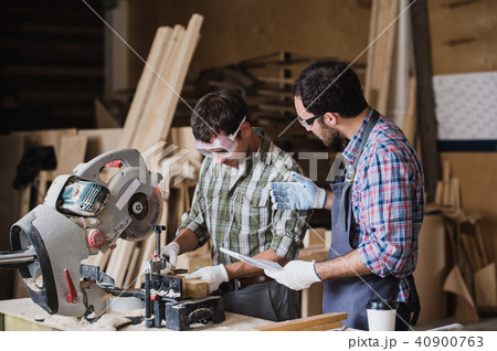 Inspector and carpenter discuss the process of making wood products for furniture Inspector and carpenter discuss the process of making wood products for furniture 40900763