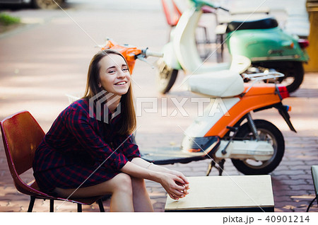 young attractive girl with beautiful smile wearing violet checkered dress and vintage old scooter 40901214