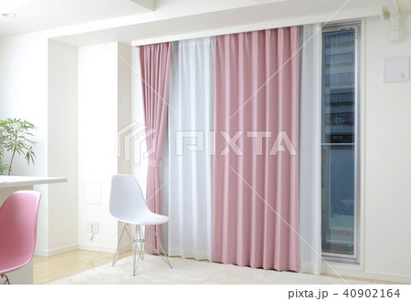 インテリア ピンク色のカーテンと白い椅子の写真素材